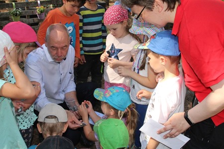 Bürgermeister Martin Feller verteilt die Anstecknadeln der Stadt an die Kinder das DRK-Waldkindergartens.