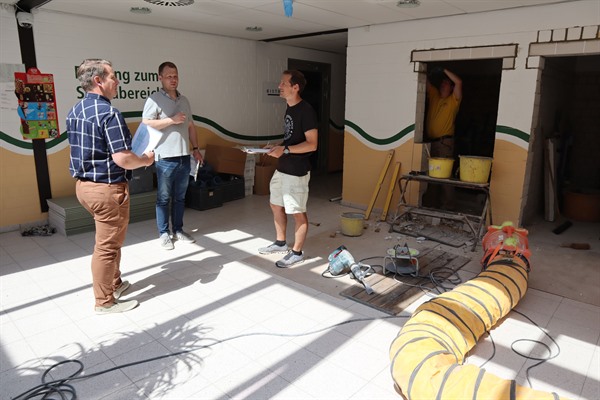 Hochbauingenieur Julian Keese (von links), Bauamtsleiter Oliver Willing und Badleiter Dominik Wolf inspizieren die Arbeiten des Sanitärbereichs im Eingangsbereich. 
